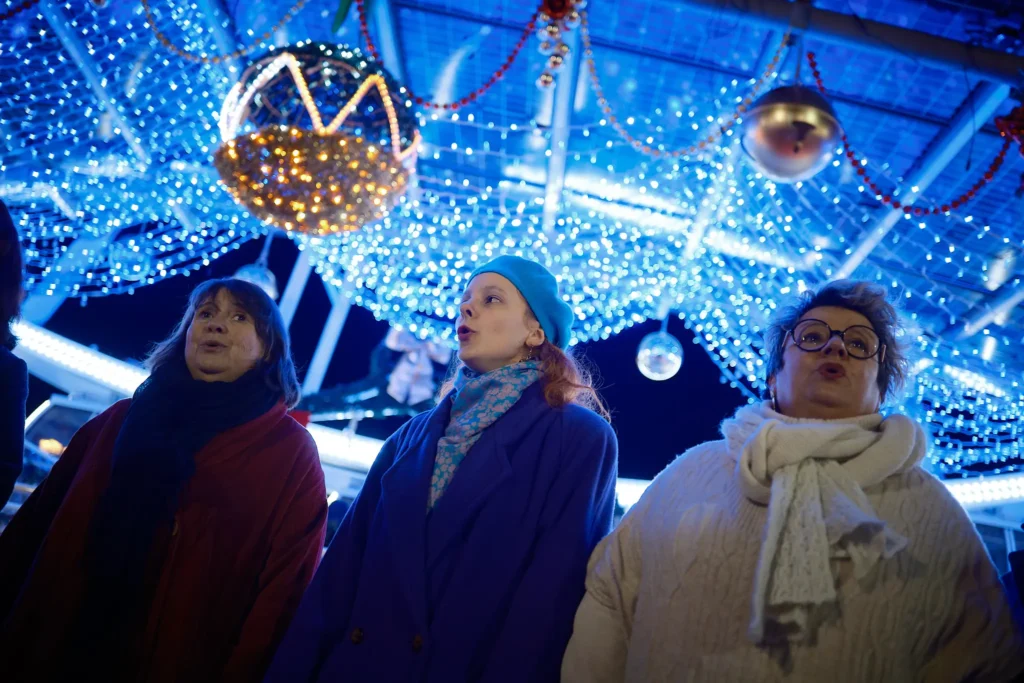 Scène de vie au Marché de Noël de Bordeaux photographiée par un photographe événementiel : commerçants, décorations et ambiance hivernale