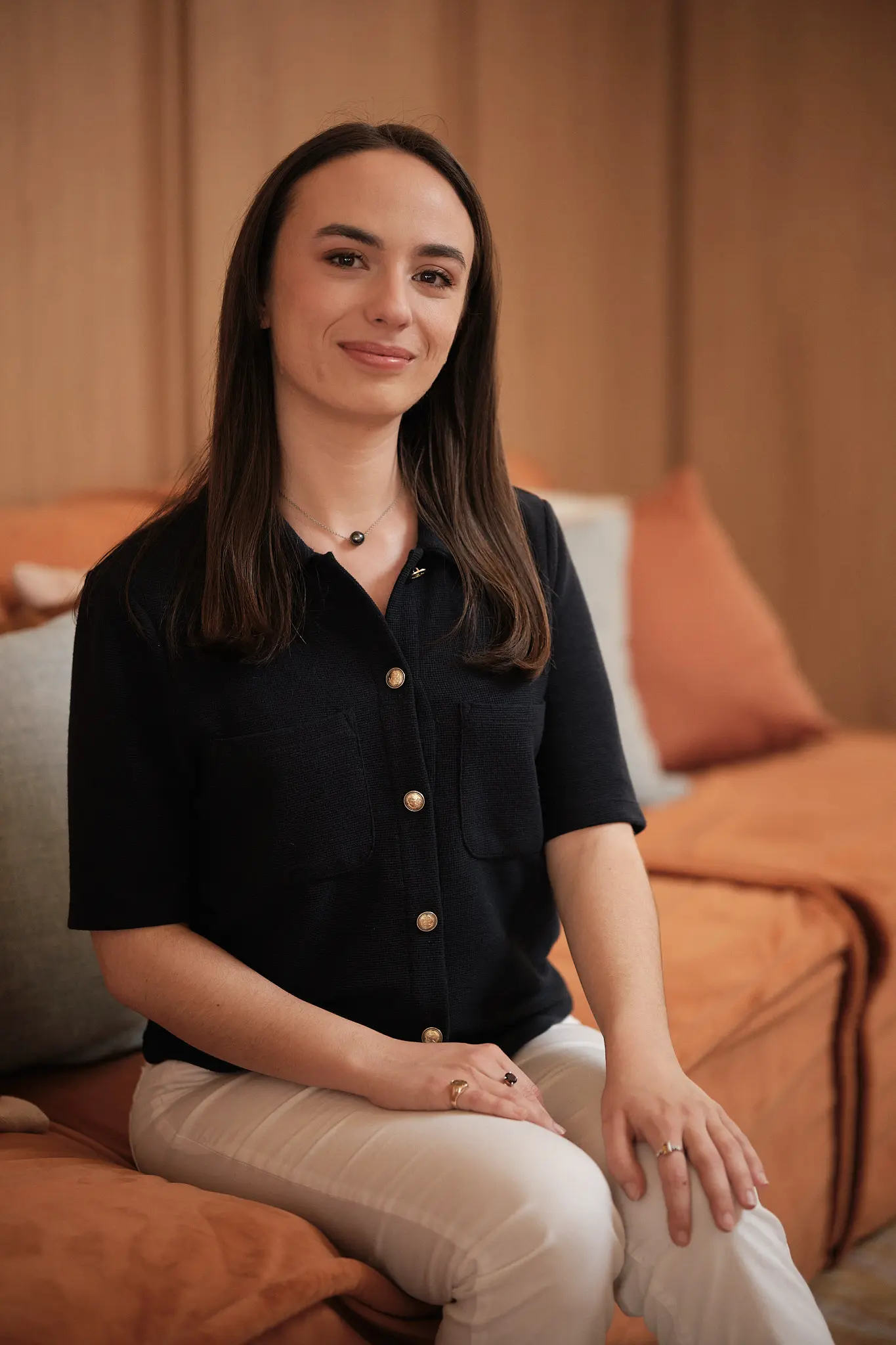 Portrait corporate d'une collaboratrice Numissima dans un environnement chaleureux aux tons terracotta