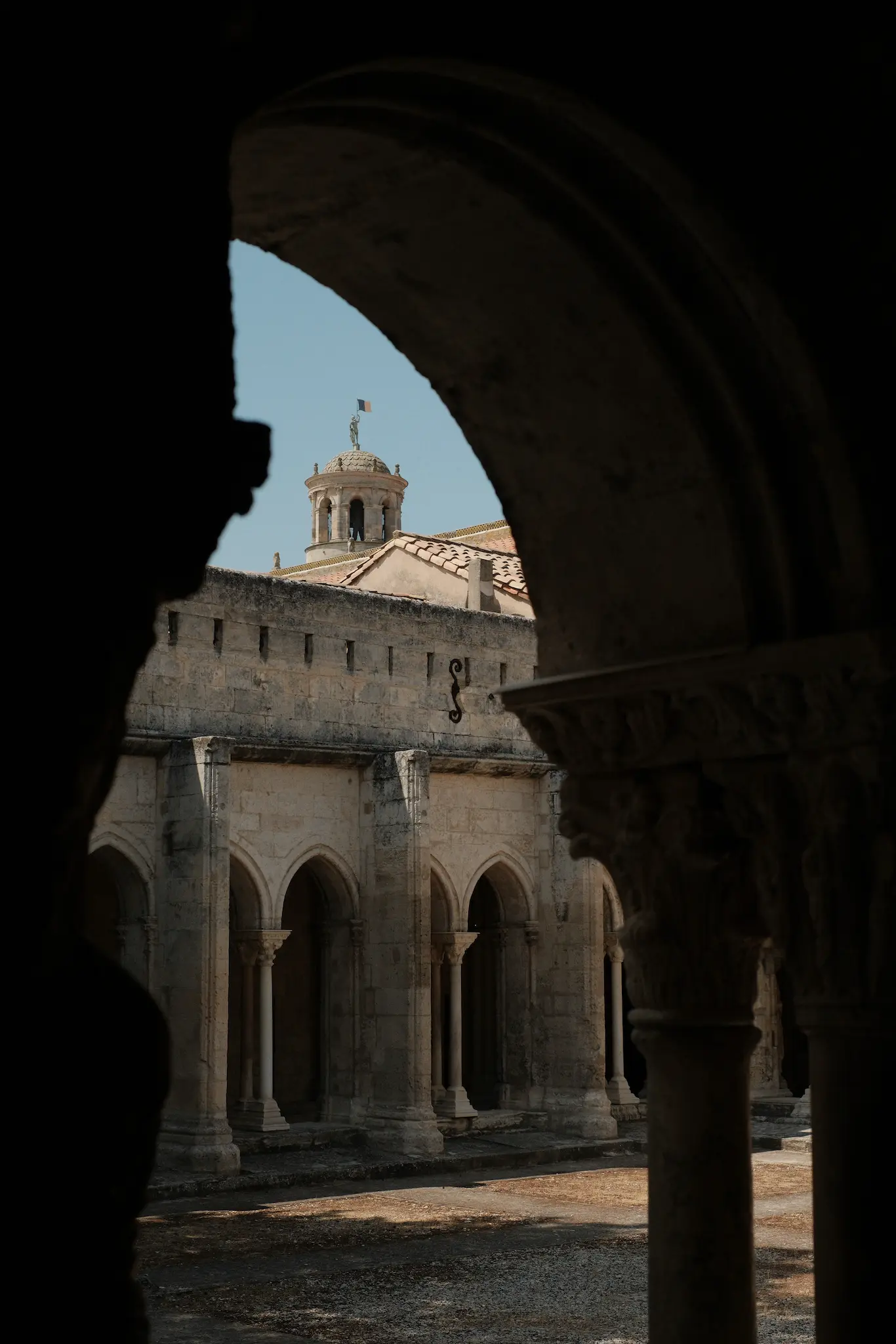 cloître roman à Arles vu à travers une arcade, preset basé sur Classic Chrome Fujifilm